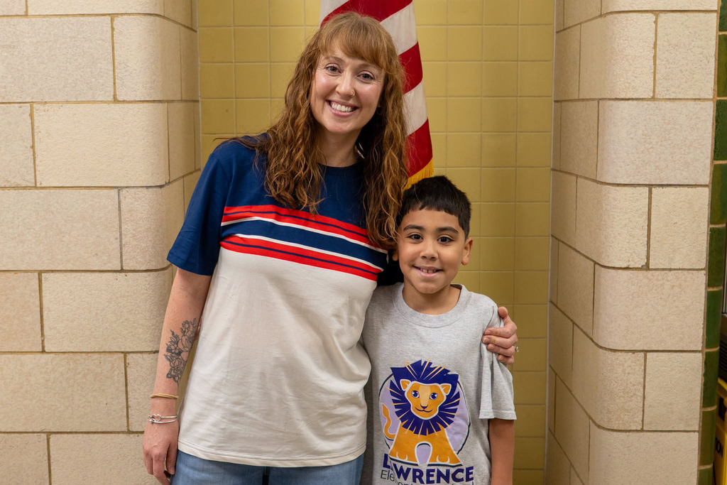 Teacher and student posing in the hallway for a photo