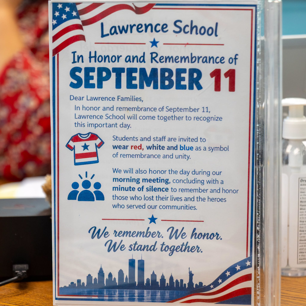 Poster hanging up in school talking about honoring and remembering 9/11 and encouraging students to wear red, white, and blue
