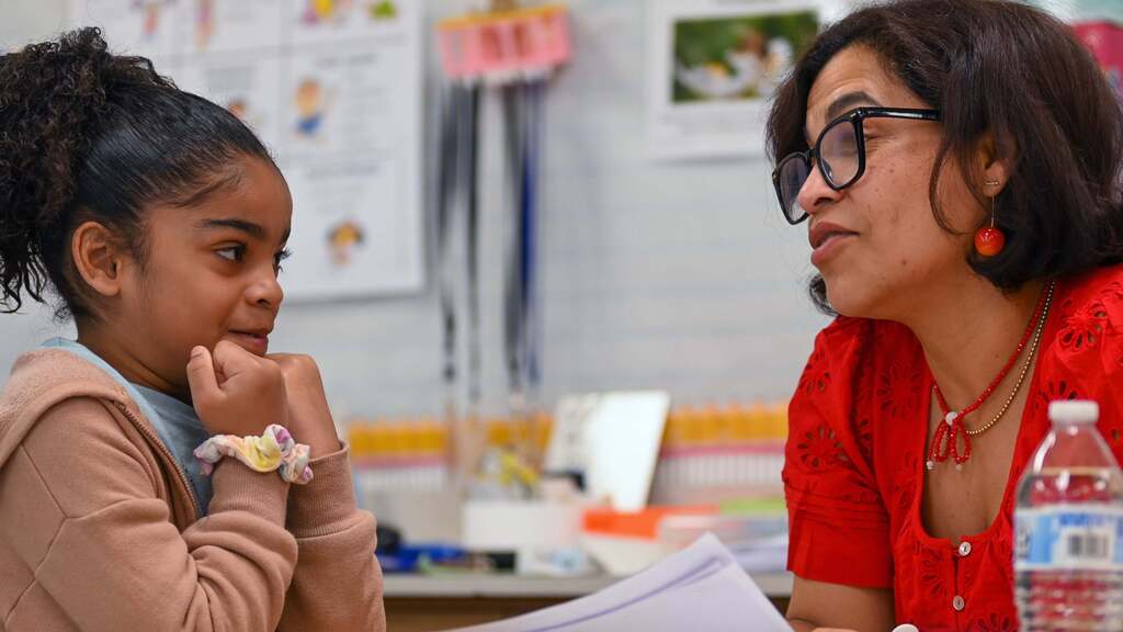 Student talks to 2nf grade teacher in the E.N. White Dual Language program