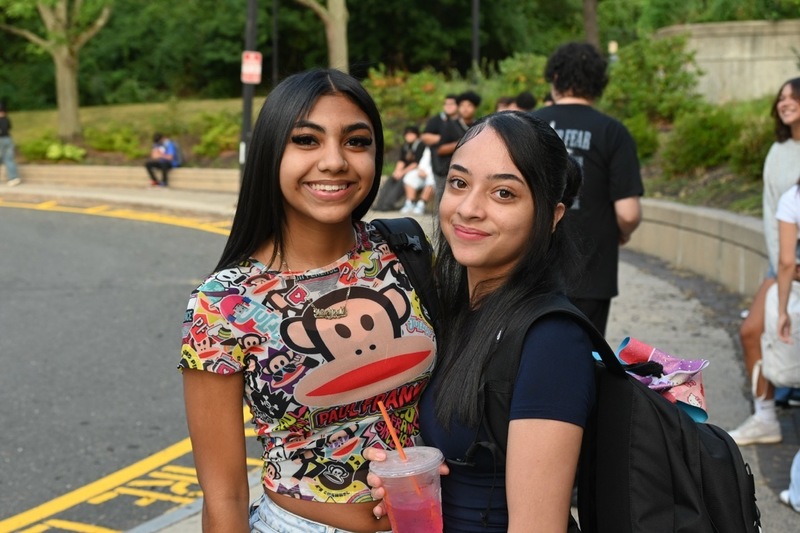 Two Dean students smile at camera outside of school