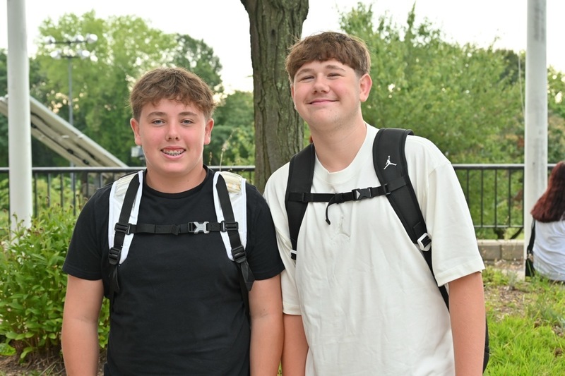 Two students smile at camera