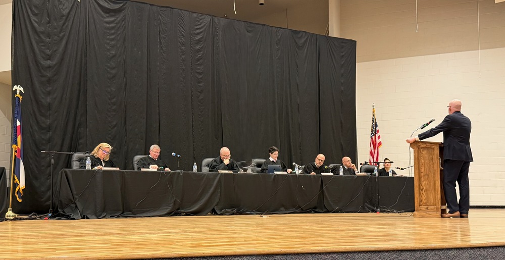 Colorado Supreme Court hearing with judges seated at a panel and a speaker at a podium.