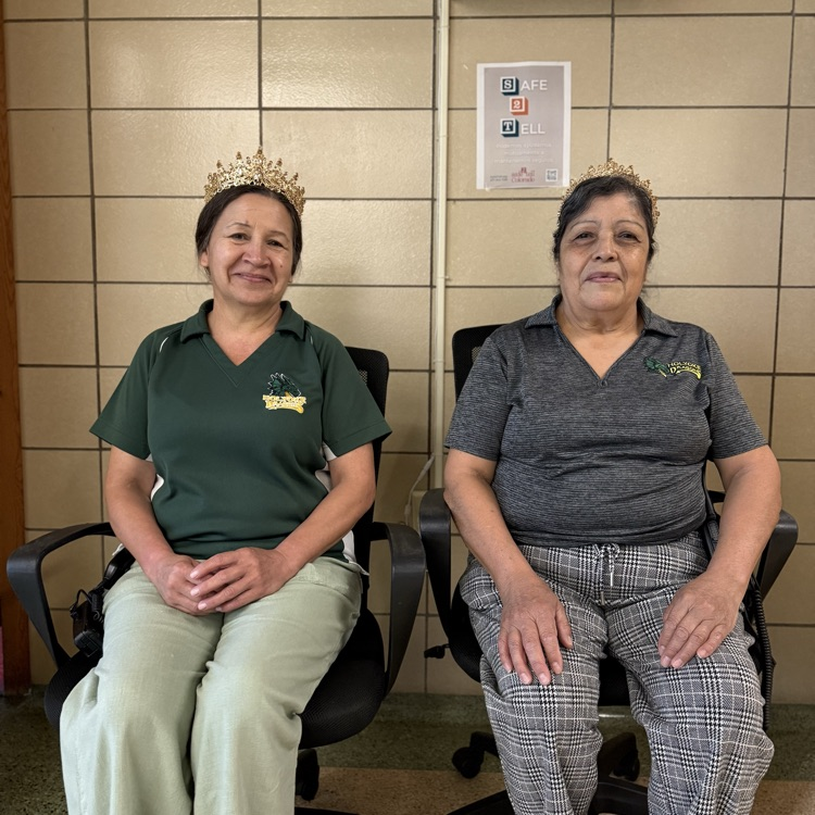 royal custodians. two ladies sitting in offfice chairs wearing tiaras  