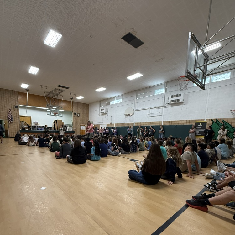 students sitting on the gym floor