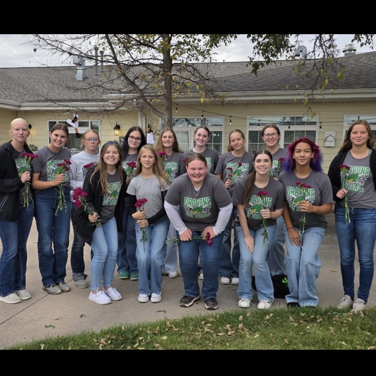girls stand in line and hold flowers
