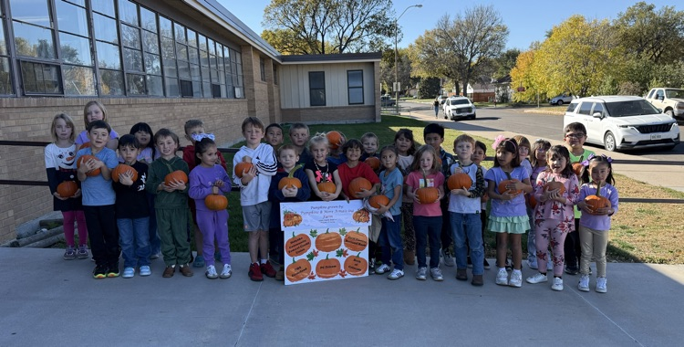 students holding pumpkins 