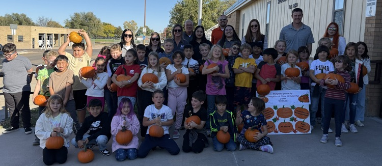 students holding pumpkins 