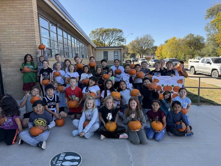 students holding pumpkins 