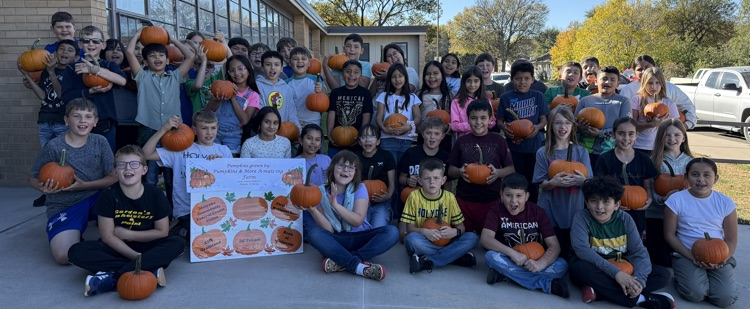 students holding pumpkins 