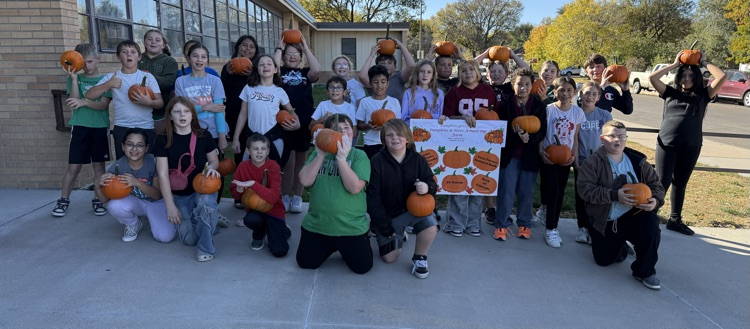 students holding pumpkins 