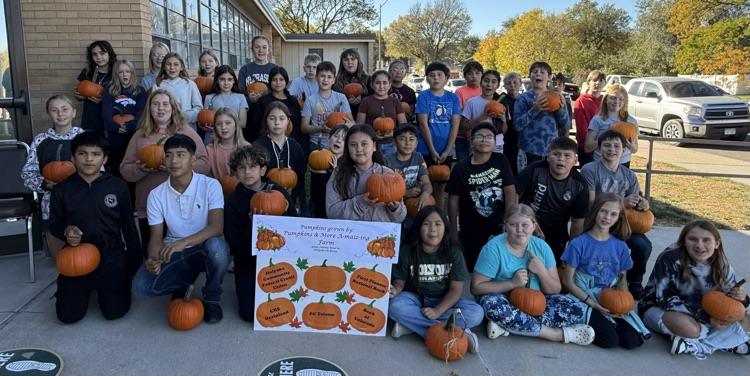 students holding pumpkins 