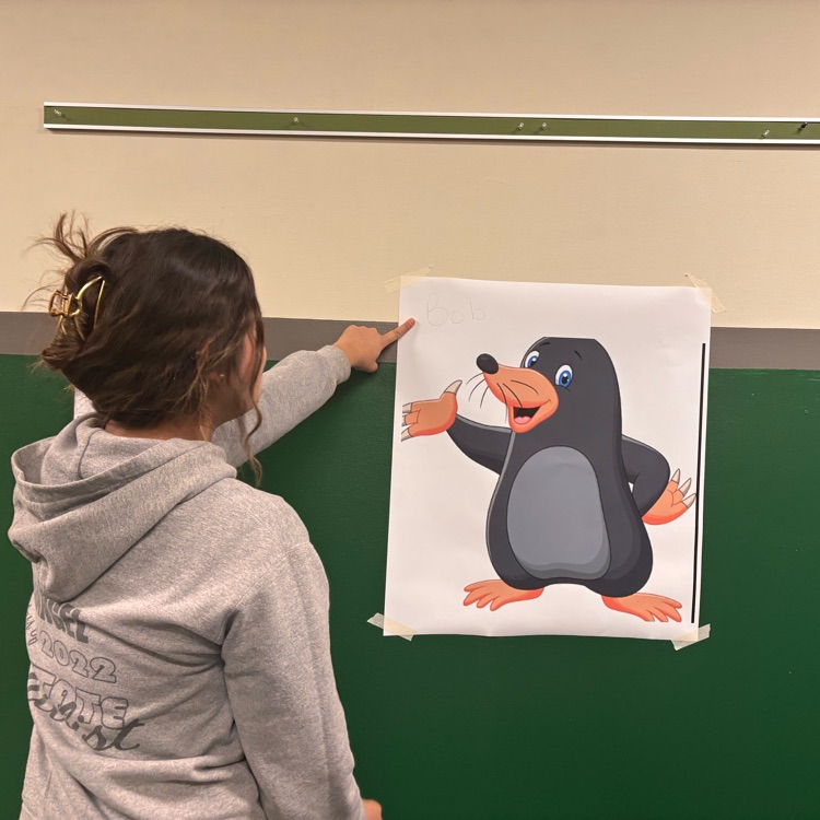 girl pointing at picture on wall