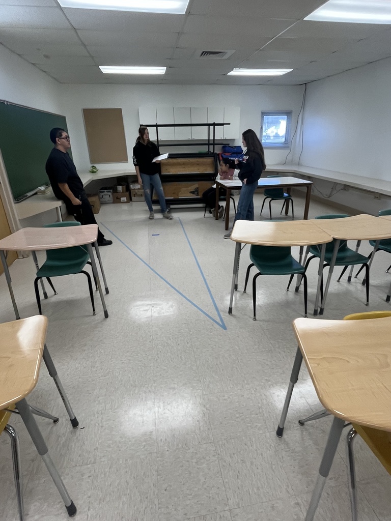 students looking at tape on floor 