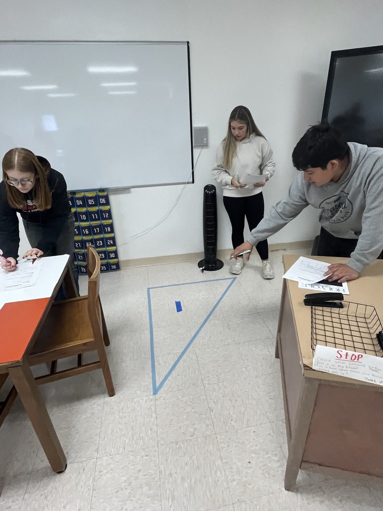 students looking at tape on floor 
