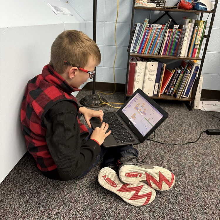 student student sitting on the floor working on a computer  