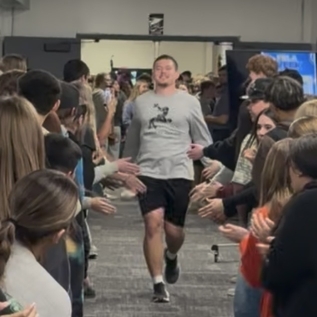student getting high-fives from other students