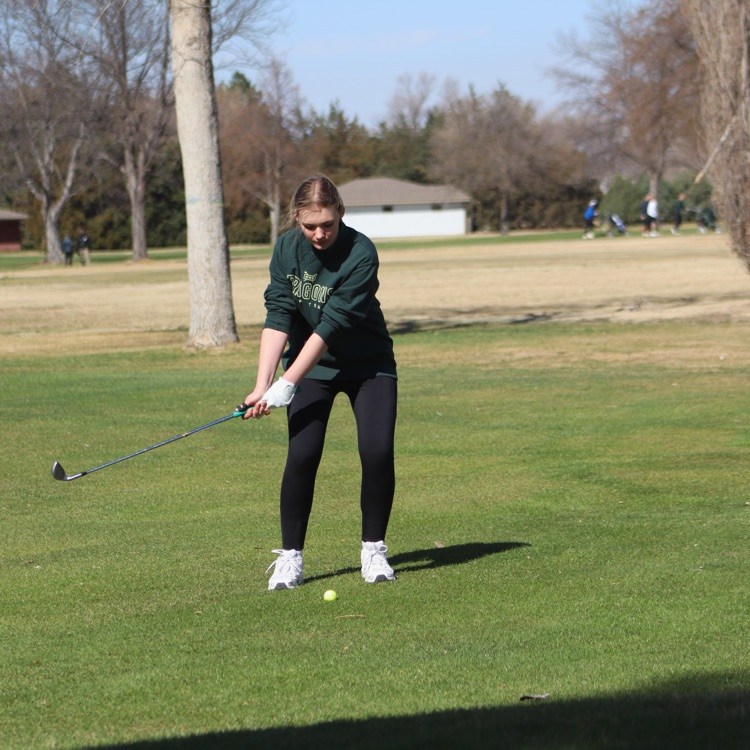 Girl prepares to swing golf club