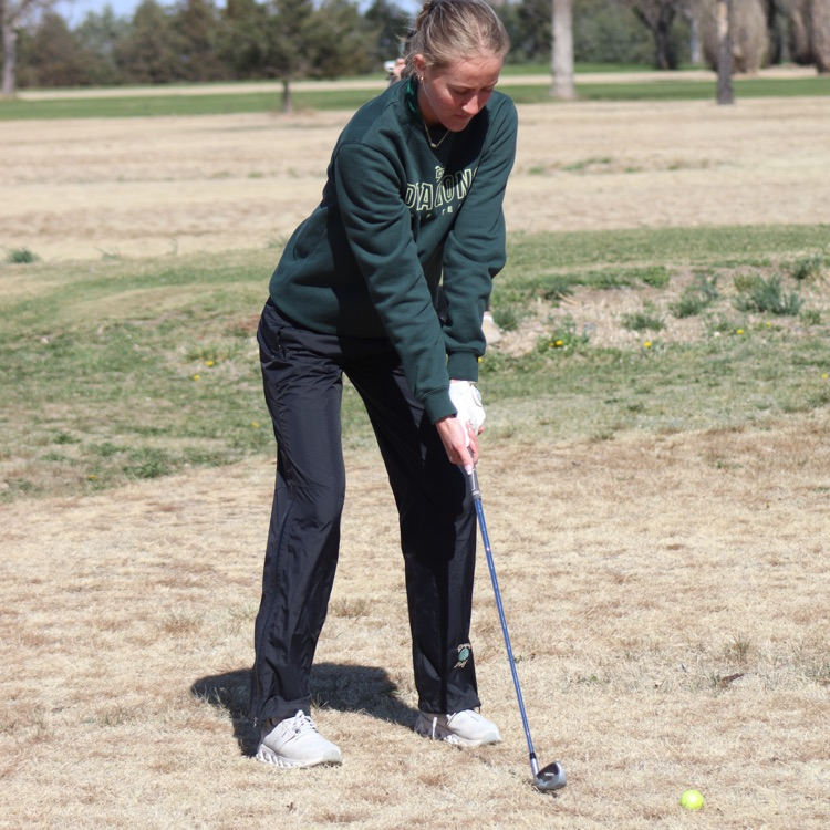 Girl prepares to swing golf club