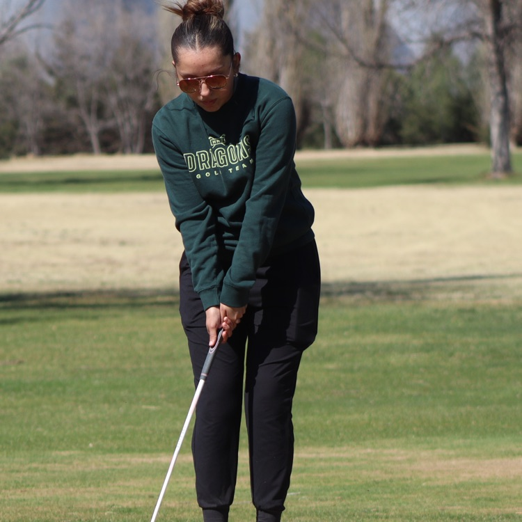 Girl prepares to swing golf club