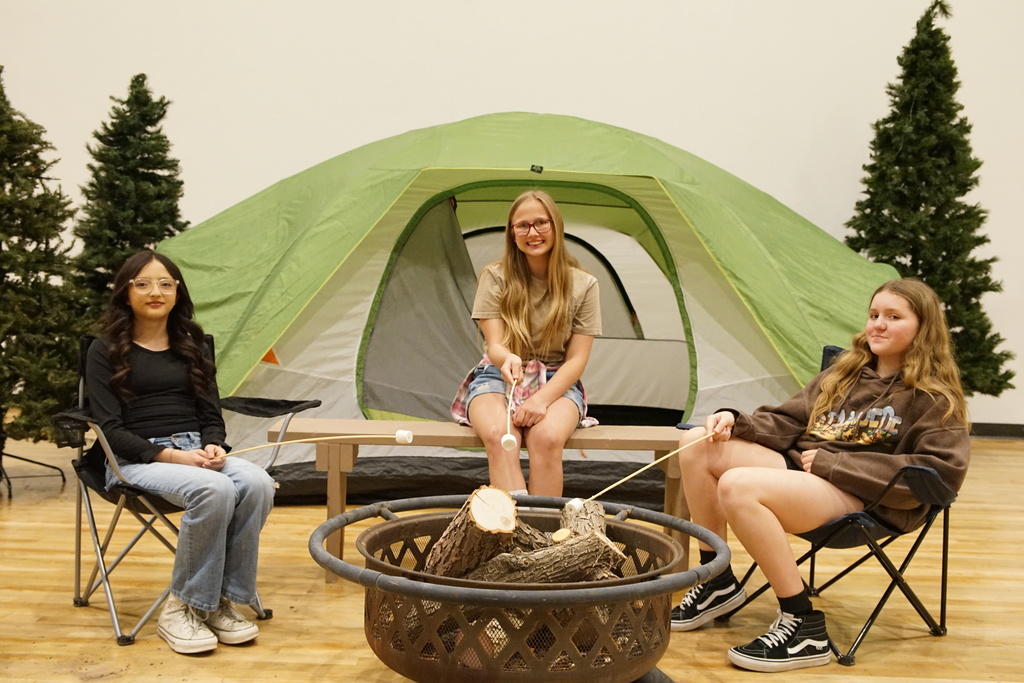 Girls sit around campfire