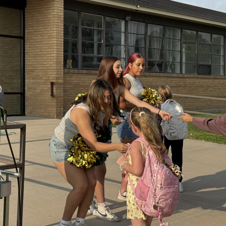 cheerleading students greet elementary students