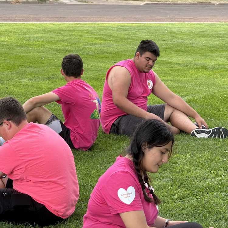 groups of students hang out together on the grass field