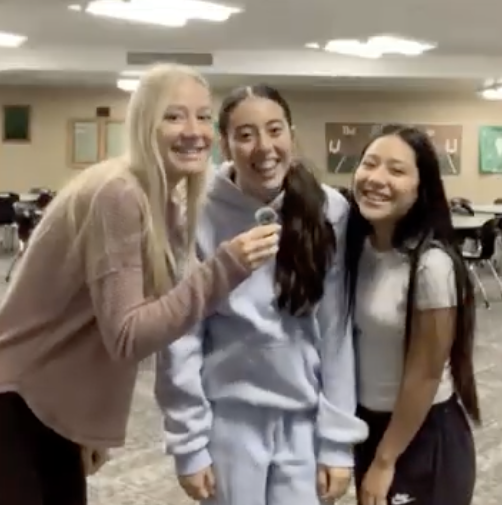 Three Girls Standing in front of a microphone.
