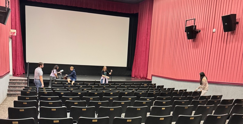 students cleaning a movie theater
