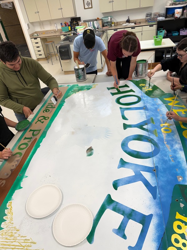 students painting a sign