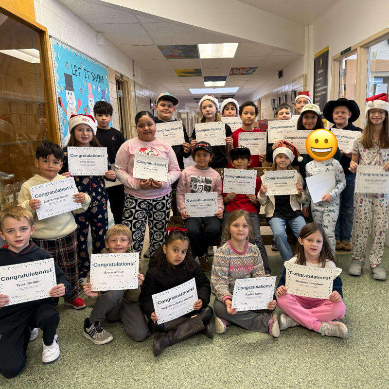 students in pajamas holding certificates