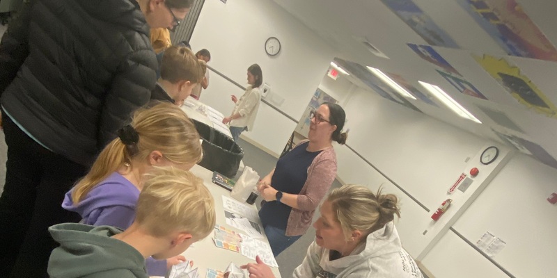 Two teachers talk to a family that stopped by their station