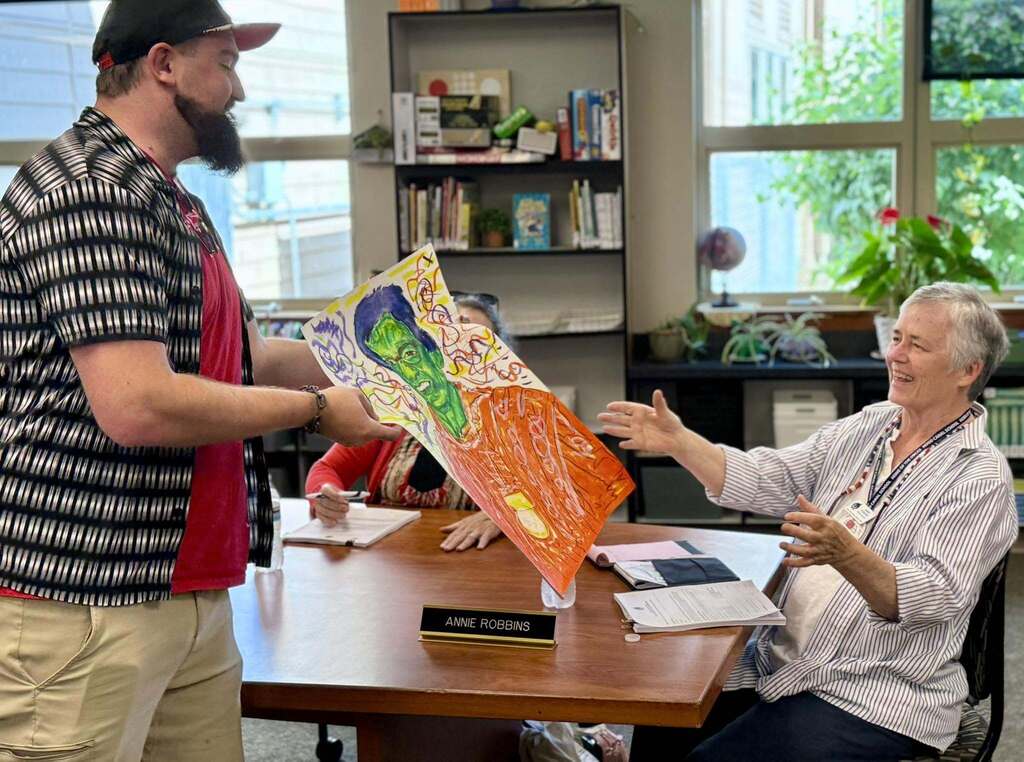 Mr. Max presenting Annie Robbins with her custom, student-drawn portrait!
