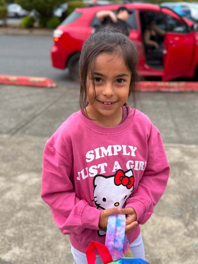 Student wearing a pink shirt arriving at school.