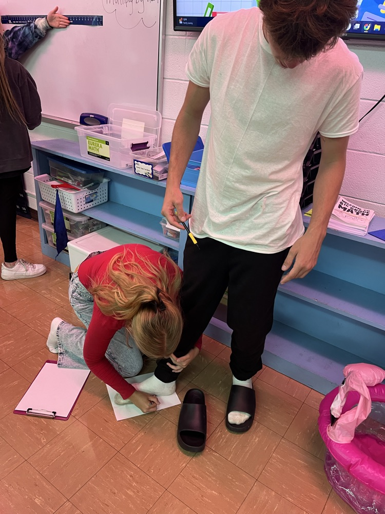 6th hour students measuring their foot size in inches 