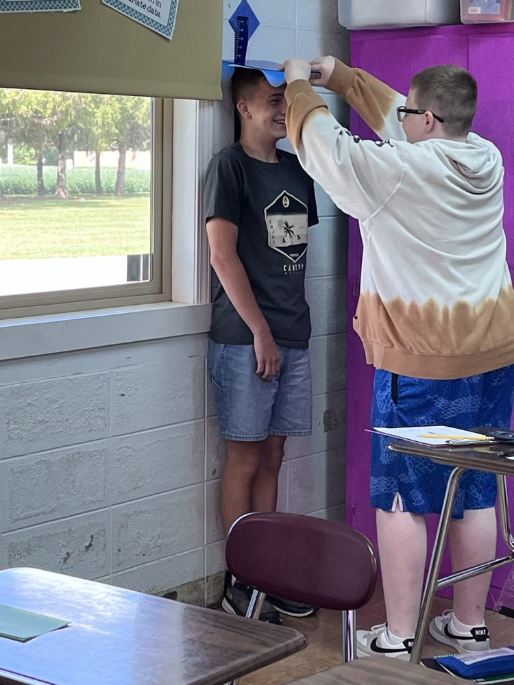 4th hour students measuring their heights in inches