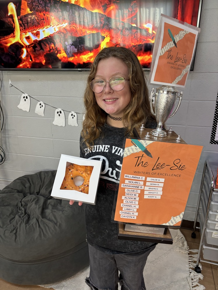 Girl smiling while holding a trophy and prize