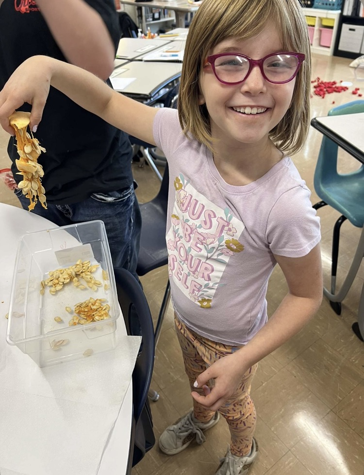 young girl student holding pumpkin seeds