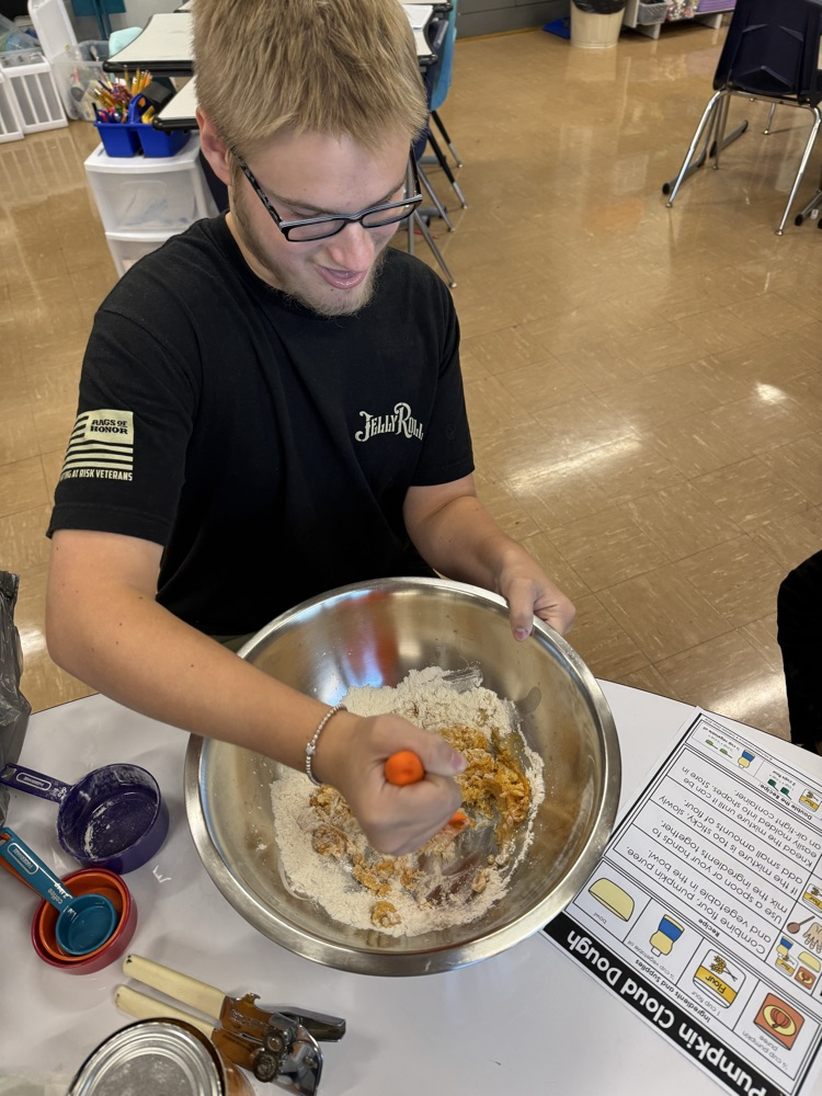 male student mixing cloud dough