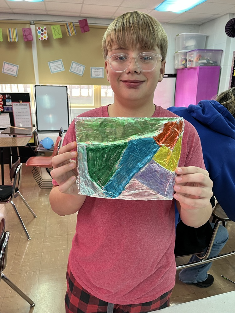 male student holding his foil craft