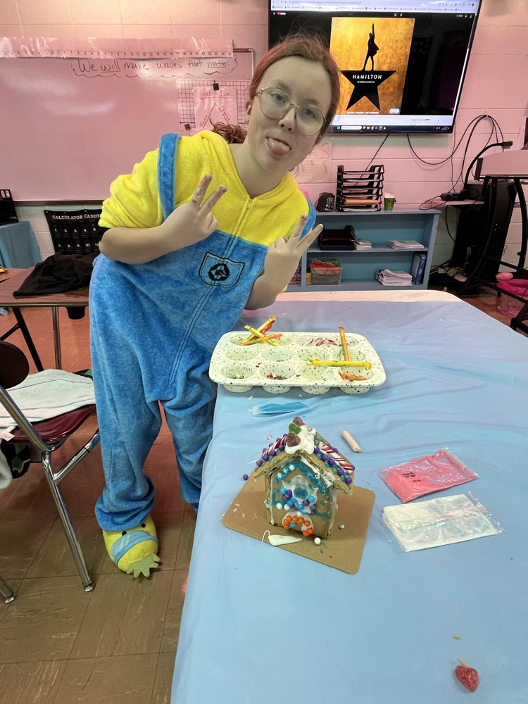 female student showing off her gingerbread house 