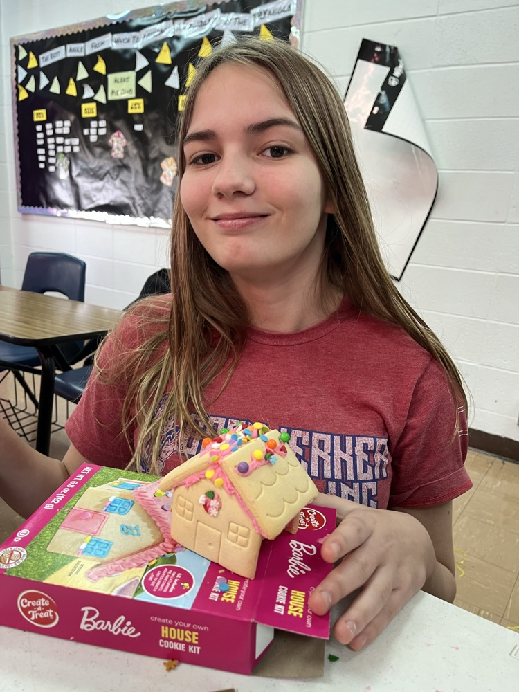 female student showing off her gingerbread house