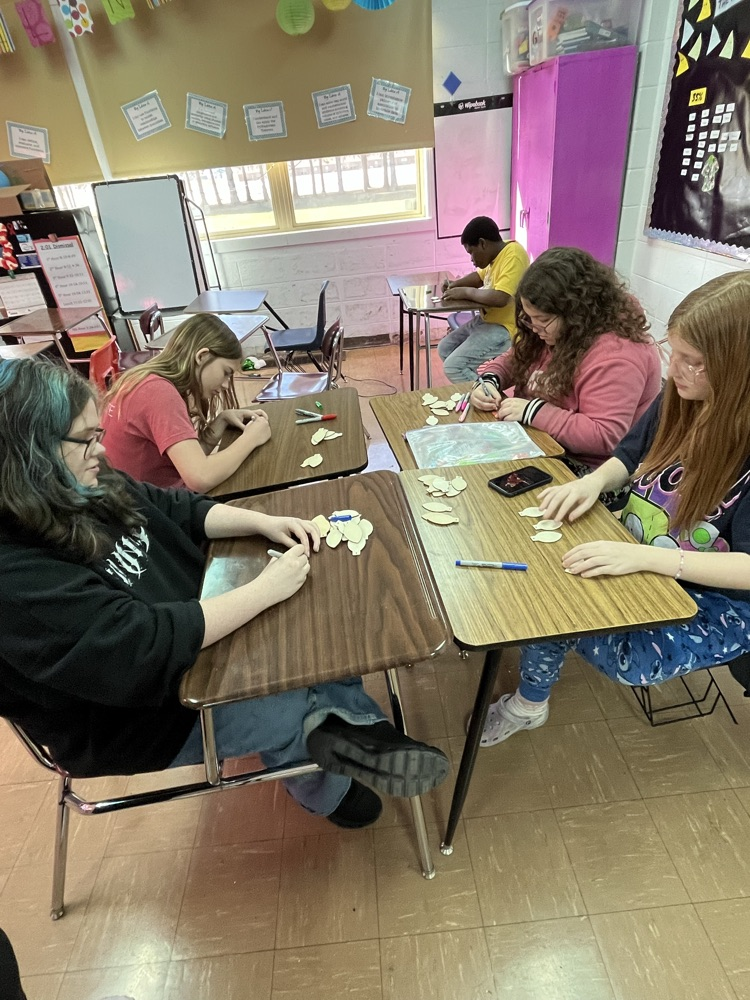 group of students making wood ornaments 