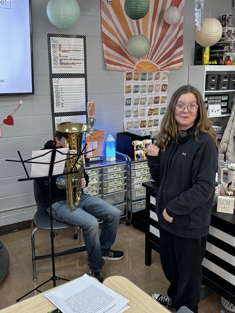 Student teaching another to play the euphonium