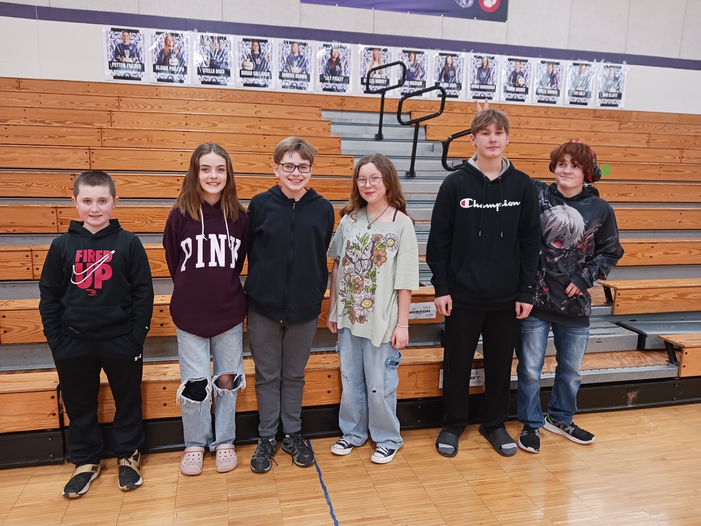 Hoopeston Area Middle School Spelling Team members posing for a picture in front of the bleachers at the Oakwood gymnasium.