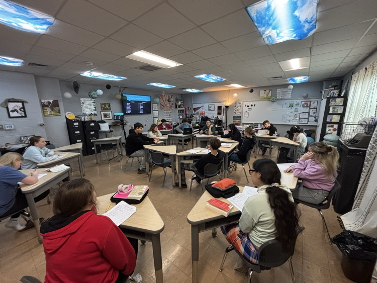 Students sit in two circles to discuss novel  