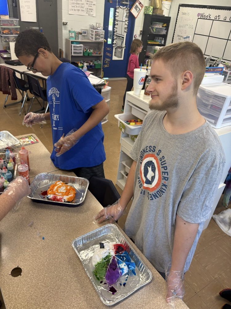 two boys working together to create their shirts 
