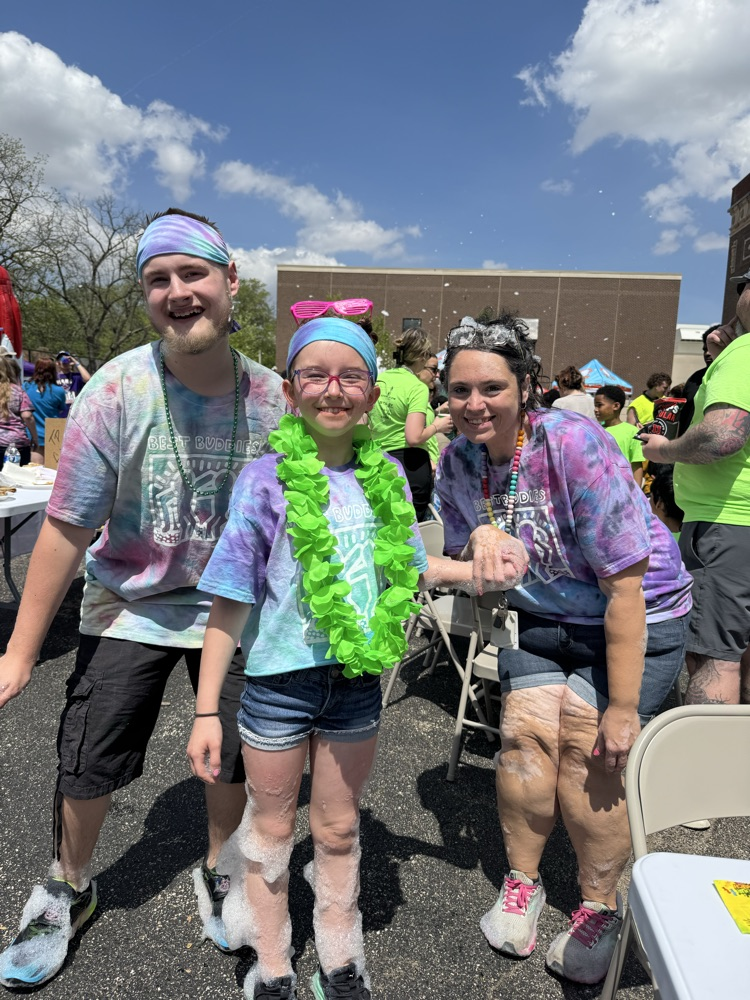 three people standing together smiling outside in tie dye 