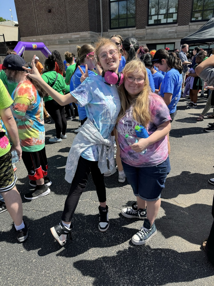 two students smiling outside in tie dye shirts 