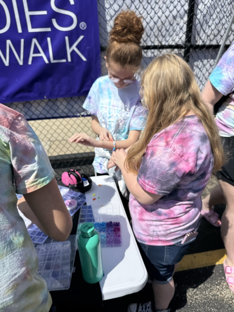 two students making friendship bracelets 
