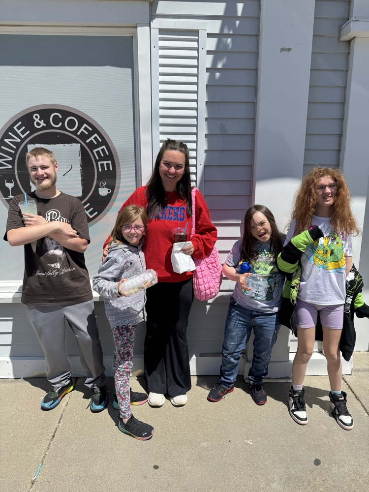 students and teacher outside coffee shop 